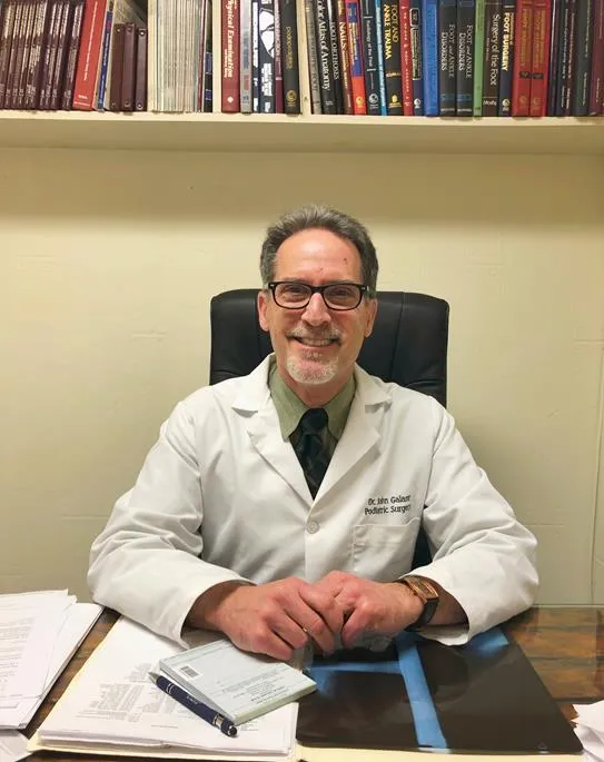 Dr. John M. Galant, DPM at his desk in the Tenafly office